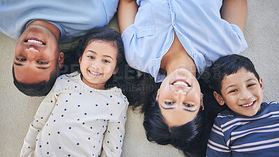 Buy stock photo Above, portrait and happy family on a floor relax, bond and playing in their home on the weekend. Face, smile and top view of children with young parents in a bedroom with love, fun and chilling