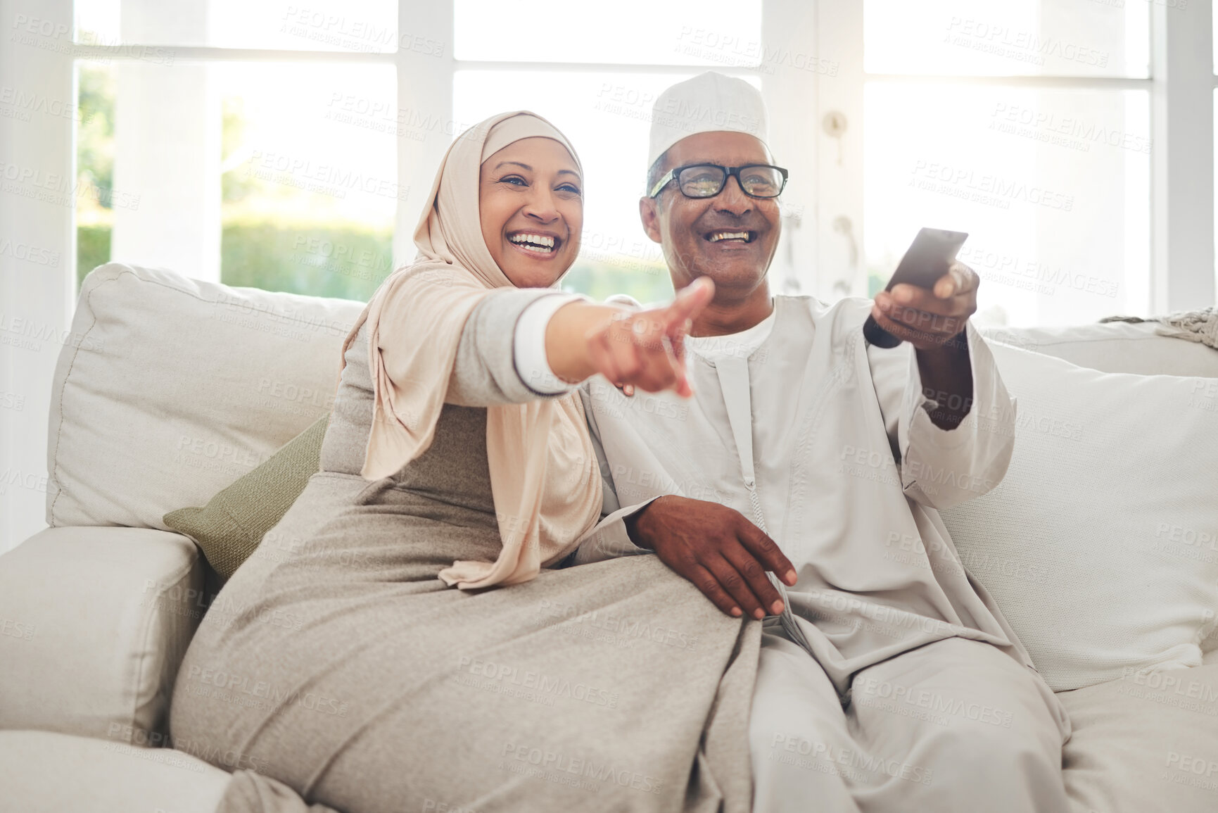 Buy stock photo Happy, muslim and watching tv with old couple on sofa for streaming, movie and funny. Television, smile and relax with senior man and woman in living room at home for comedy, retirement and lounge