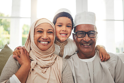 Buy stock photo Portrait, Islam and grandparents with child for Eid with happy family in home with culture in Indonesia. Senior Muslim man, old woman in hijab and kid with smile on face on sofa together in lounge.