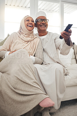 Buy stock photo Relax, muslim and watching tv with old couple on sofa for streaming, movie and funny. Television, smile and happy with senior man and woman in living room at home for comedy, retirement and lounge