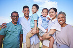 Big family, children and happy portrait on blue sky outdoor for fun, adventure and play on vacation. Young parents, grandparents and kids or hispanic people on nature holiday or at park with a smile