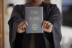 Hands, lawyer or advocate with book, constitution research or education for learning the justice system. Woman, judge or closeup of attorney studying knowledge, guide or information for legal agency
