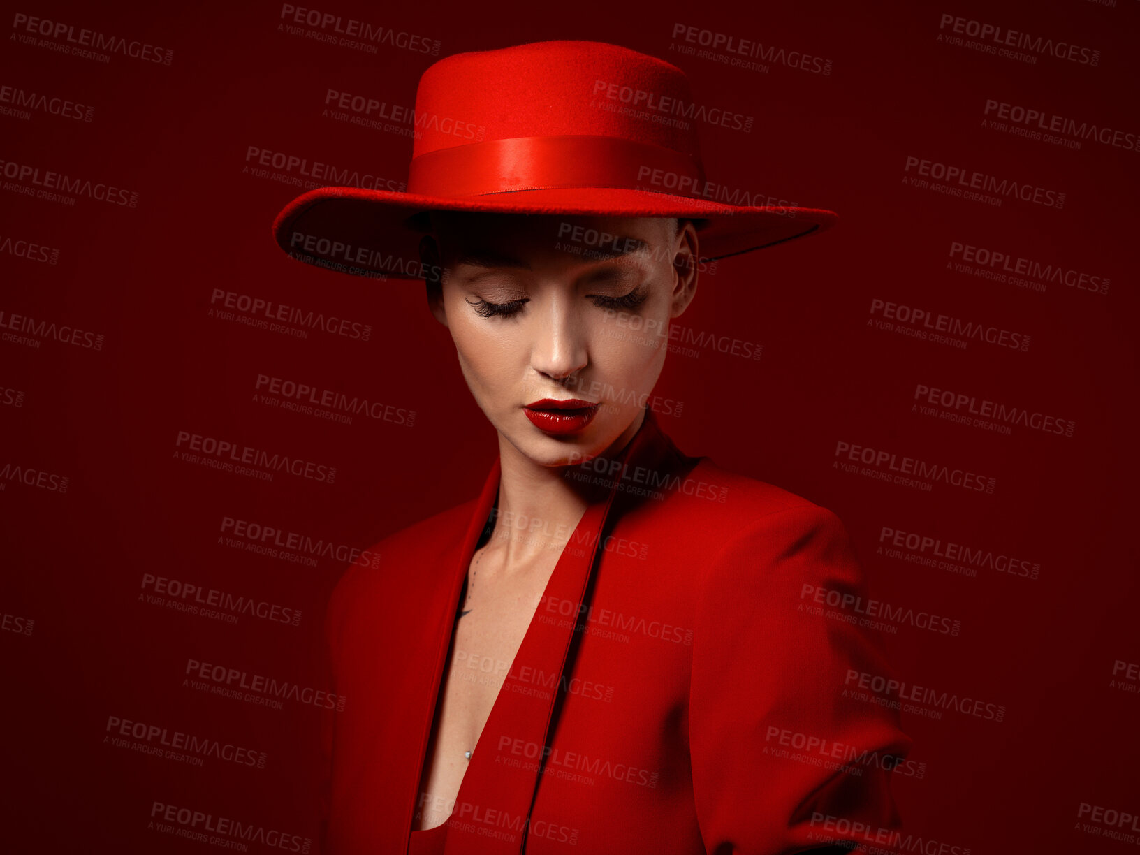 Buy stock photo Beauty, fashion and a model woman on red background in studio for elegant or trendy style. Aesthetic, art and confident with an edgy or classy young female person eyes closed in a unique clothes suit