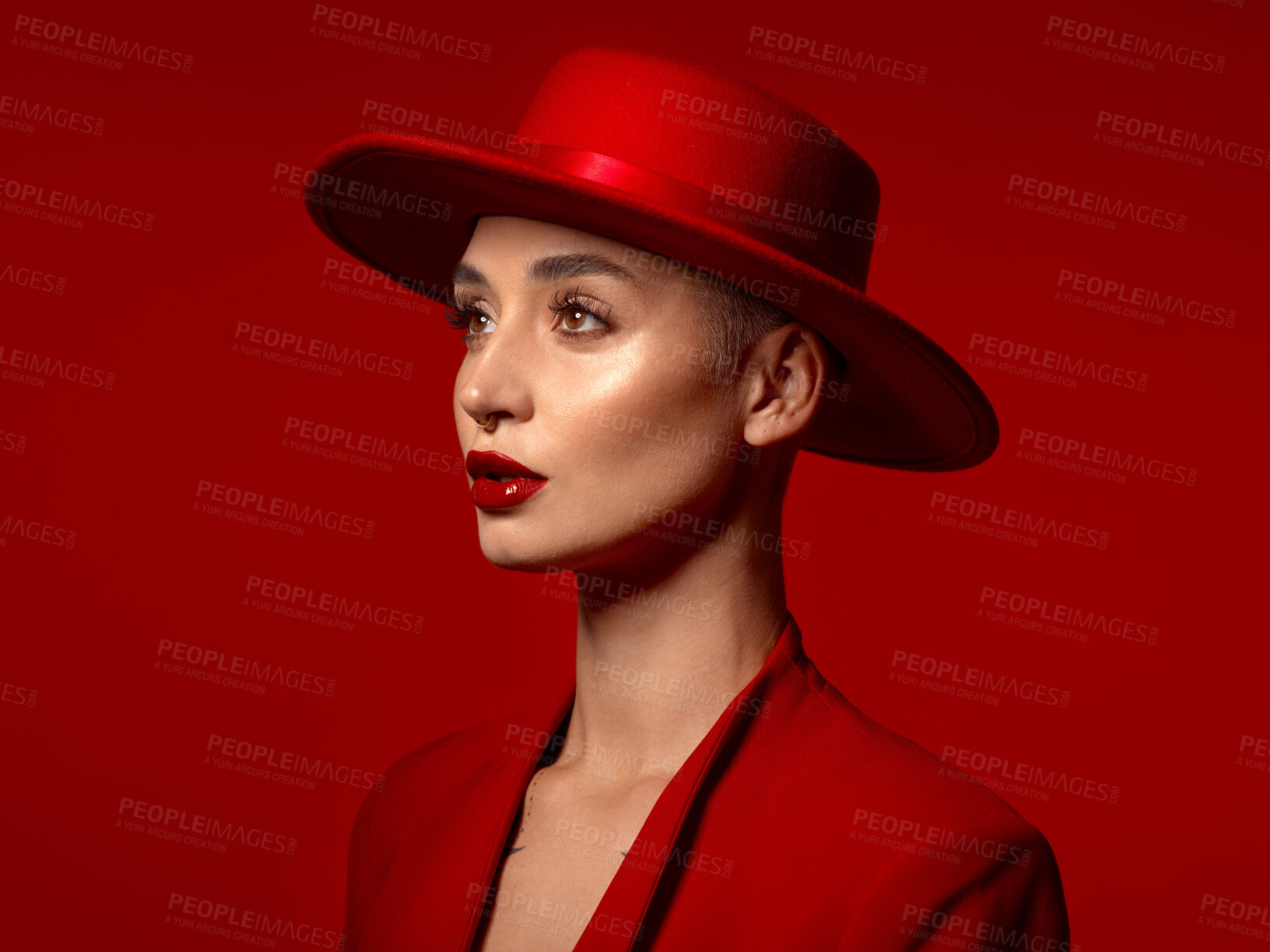 Buy stock photo Vision, fashion and a model woman on a red studio background for elegant or trendy style. Aesthetic, art and hat with a young female person looking edgy or classy in a suit or unique clothes