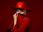 Portrait, fashion and cover with a woman on a red studio background for elegant or trendy style. Aesthetic, art and beauty with a young female model looking edgy or classy in a suit or unique clothes