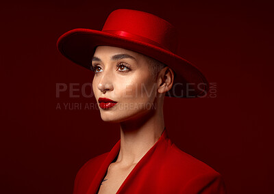 Buy stock photo Face, fashion and a model woman on a red studio background for elegant or trendy style. Vision, art and beauty with a confident young female person looking edgy or classy in a suit or unique clothes