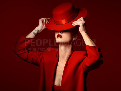 Buy stock photo Woman, red aesthetic and hat in studio with makeup art, thinking and mystery with couture, vision and background. Girl, model and high fashion with suit, mindset and facial paint for cosmetic beauty