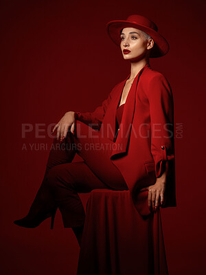 Buy stock photo Thinking, fashion and a woman sitting on a red studio background for elegant or trendy style. Vision, art and beauty on a chair with a young female model looking edgy or classy in suit clothes
