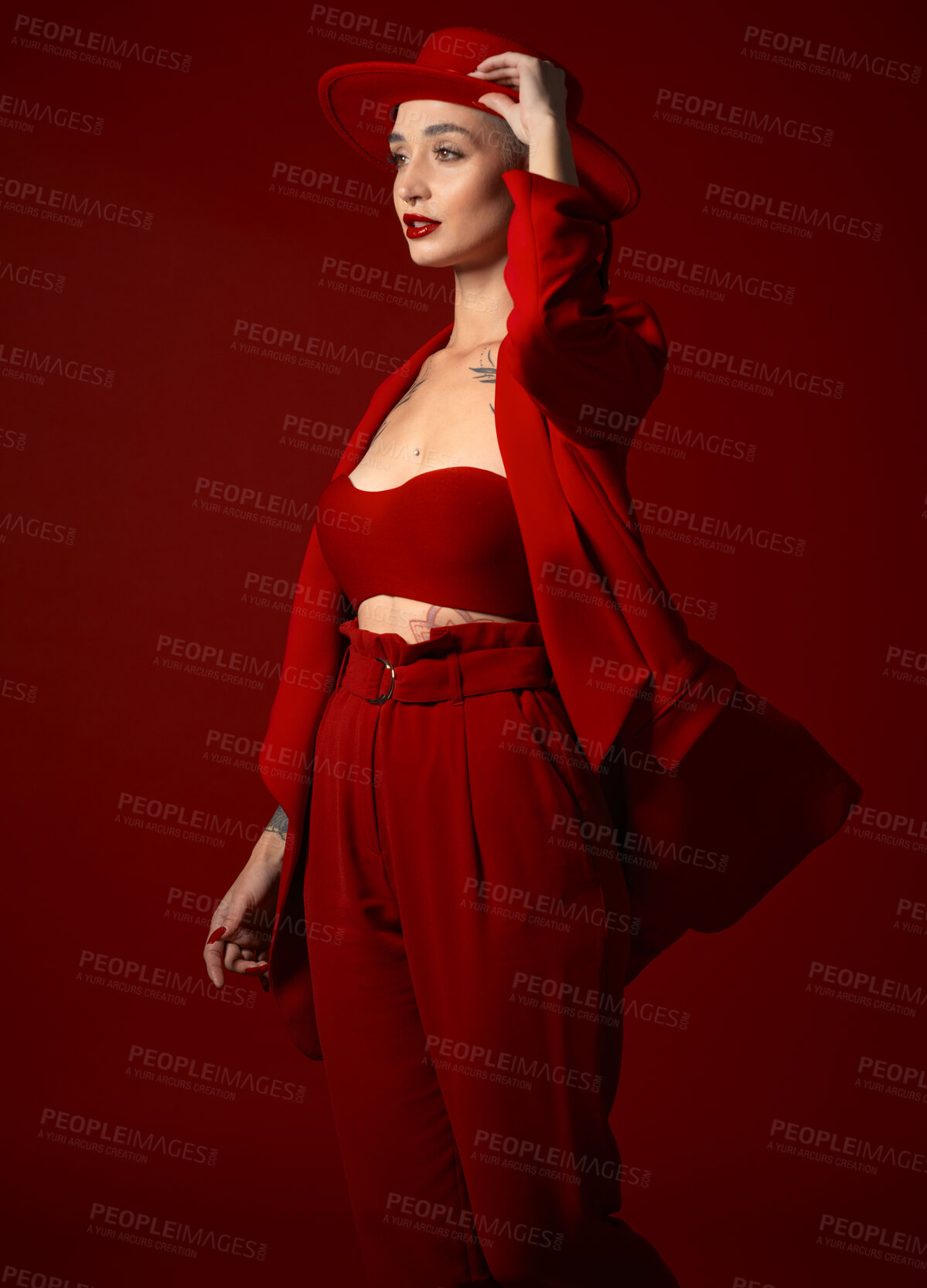 Buy stock photo Vision, fashion and a woman in a hat on a red background in studio for elegant or trendy style. Aesthetic, beauty and future with a confident young female person looking edgy or classy in a bold suit