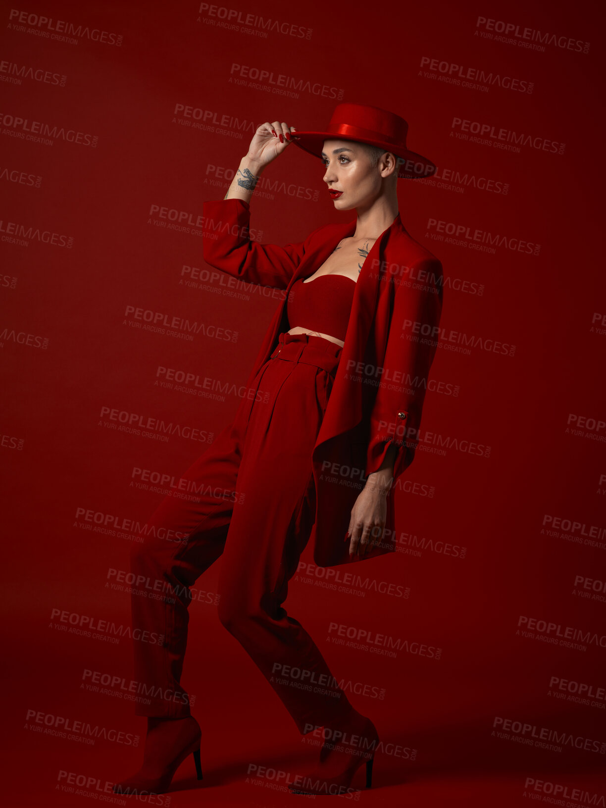 Buy stock photo Aesthetic, fashion and a woman walking on a red studio background for elegant or trendy style. Runway model, art or beauty with a confident young female person looking edgy and classy in a bold suit