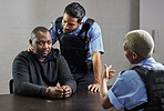 Police, criminal and handcuffs for interrogation, arrest or justice in fraud, scam or crime. Law enforcement officers talking to prisoner, gangster or thief in question for robbery in prison or jail