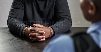 Buy stock photo Criminal, hands and handcuffs and table for interrogation, questions or accusation with officer in room. Police talking to prisoner, gangster or thief for security, discussion or arrest in prison