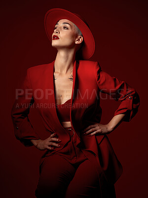 Buy stock photo Confident, fashion and a model woman on a red studio background for elegant or trendy style. Aesthetic, art and beauty with a young female person standing hands on hips in an edgy or classy suit
