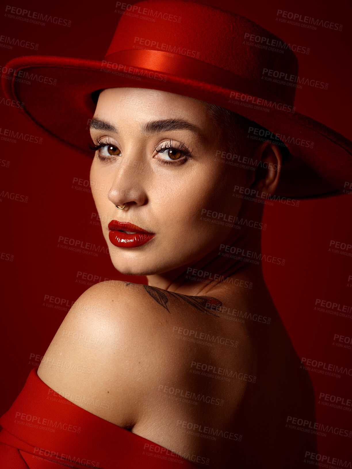 Buy stock photo Portrait, fashion and looking back with a woman on a red studio background for elegant or trendy style. Face, art and beauty with a young female model posing closeup in an edgy or classy outfit
