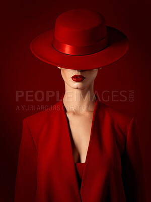 Buy stock photo Vintage, fashion and woman in a suit or hat in studio with retro, style and edgy, confident or creative pose on red background. Mystery character, model and girl with power, beauty or aesthetic
