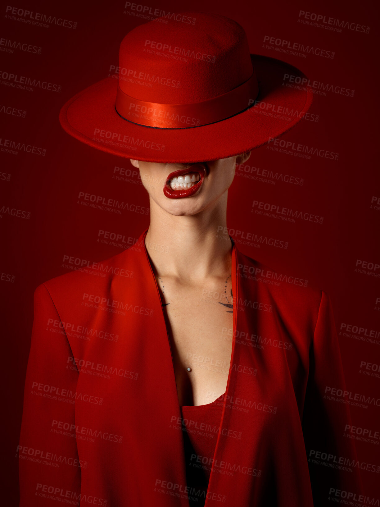 Buy stock photo Woman, red aesthetic and makeup with hat, art and teeth out for couture, emoji and studio background. Girl, model and high fashion with suit, attitude and sexy with beauty, lipstick and cosmetics