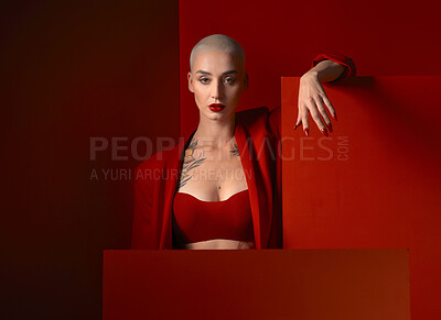 Buy stock photo Portrait, fashion and mockup with a woman on a red background in studio for marketing, advertising or branding. Luxury, aesthetic style or a trendy young female model standing with an empty poster