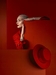 Fashion, space and a model woman in a red background in studio for marketing, advertising or branding. Vision, aesthetic style or a trendy young female person standing with an empty or blank poster