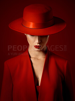 Buy stock photo Suit, hat and woman with fashion or beauty in studio with retro, style or edgy, confident or creative pose on red background mockup. Mystery character, model and girl with power or vintage aesthetic