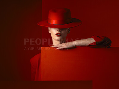 Buy stock photo Hat, fashion and mockup with a woman on a red background in studio for marketing, advertising or branding. Luxury, aesthetic style or a trendy young female person standing with empty poster space