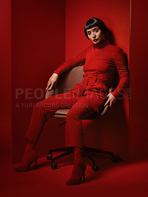 Buy stock photo Chair, fashion and a model woman on red background in studio for elegant, chic or trendy style. Aesthetic, art and confident beauty with an edgy or classy young person in a unique clothes or suit