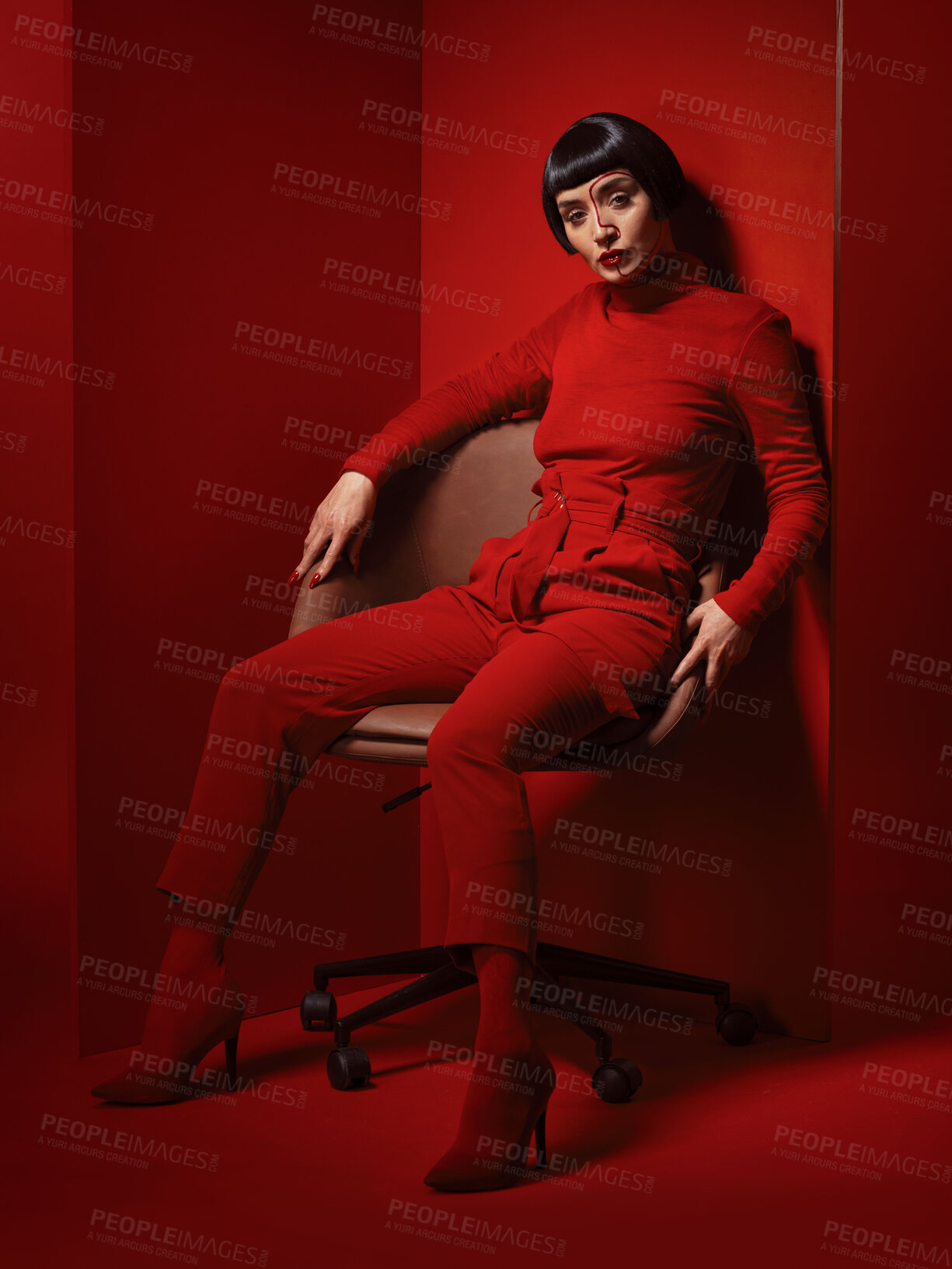 Buy stock photo Chair, fashion and a model woman on red background in studio for elegant, chic or trendy style. Aesthetic, art and confident beauty with an edgy or classy young person in a unique clothes or suit
