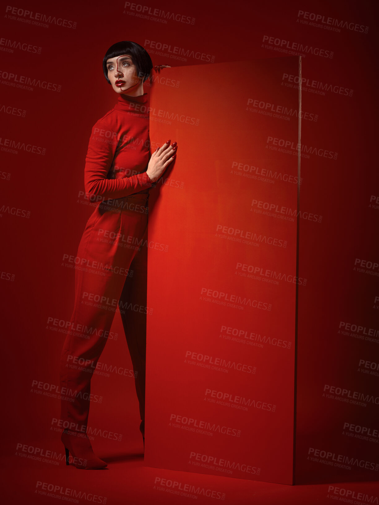 Buy stock photo Beauty, fashion and a model woman on red background in studio for elegant, chic or trendy style. Aesthetic, art and confident with an edgy or classy young person in a unique clothes or suit at board