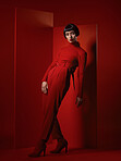 Fashion, retro and portrait of a woman on a red background for a sexy, creative and vintage aesthetic. Pose, luxury and a model in clothing with wealth and makeup isolated on a studio backdrop