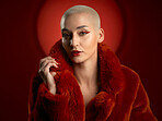 Fashion, portrait and confident woman in a red coat in studio isolated on a background. Face, makeup and serious model with cosmetics, aesthetic and style, trendy and fur clothes from Switzerland.