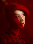Woman, fashion and makeup with red aesthetic, beauty and art deco with vintage hat isolated on studio background. Retro style, female model with serious expression and cosmetics, attractive and bold
