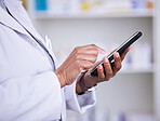 Woman, hands and phone of pharmacist typing in research, communication or online browsing at pharmacy. Closeup of female person, medical or healthcare professional on mobile smartphone app at clinic