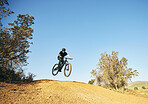 Downhill, mountain bike and man outdoor in nature for extreme sports, training or workout. Hill, countryside and male person with courage or bicycle stunt for off road cycling, travel or adventure