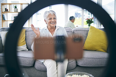 Buy stock photo Mature woman, live streaming and vlog in home for social media, chat broadcast or wave to audience online. Happy lady, content creator and filming digital podcast in living room, phone and ring light