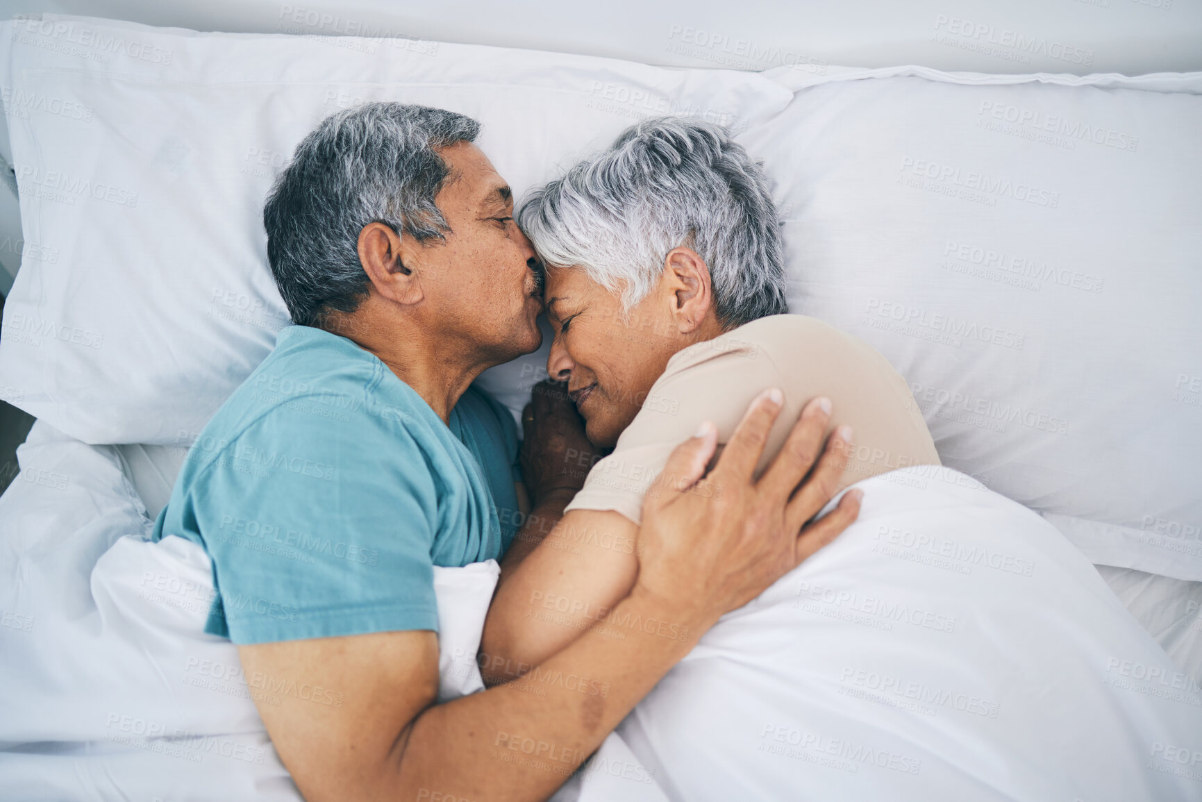 Buy stock photo Top view, hug and senior couple in bed, love and sleeping with retirement, wake up or happiness with a kiss. Romance, old man or elderly woman embrace, bedroom or holiday with marriage or loving