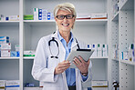 Senior woman, pharmacist and clinic tablet portrait with medical stock and digital information. Pharmacy, healthcare store and pills with elderly female employee with a smile with pills information 