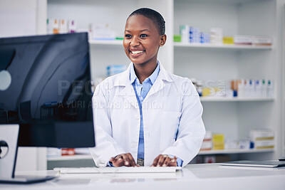 Buy stock photo Pharmacist, typing and happy black woman on computer in pharmacy, drugstore or shop. Smile, medical professional and African doctor on internet for telehealth, healthcare and research for medicine.