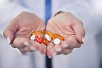 Woman, pharmacist and hands with pills for cure, pain relief or medication at the pharmacy store. Closeup of female person, medical or healthcare professional with tablets, drugs or pharmaceuticals