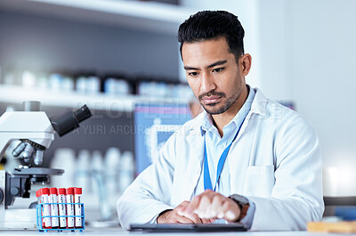Buy stock photo Scientist man, tablet and typing in laboratory with thinking, medical research and blood for pharma development. Young pharmaceutical expert, digital touchscreen or focus for innovation in healthcare