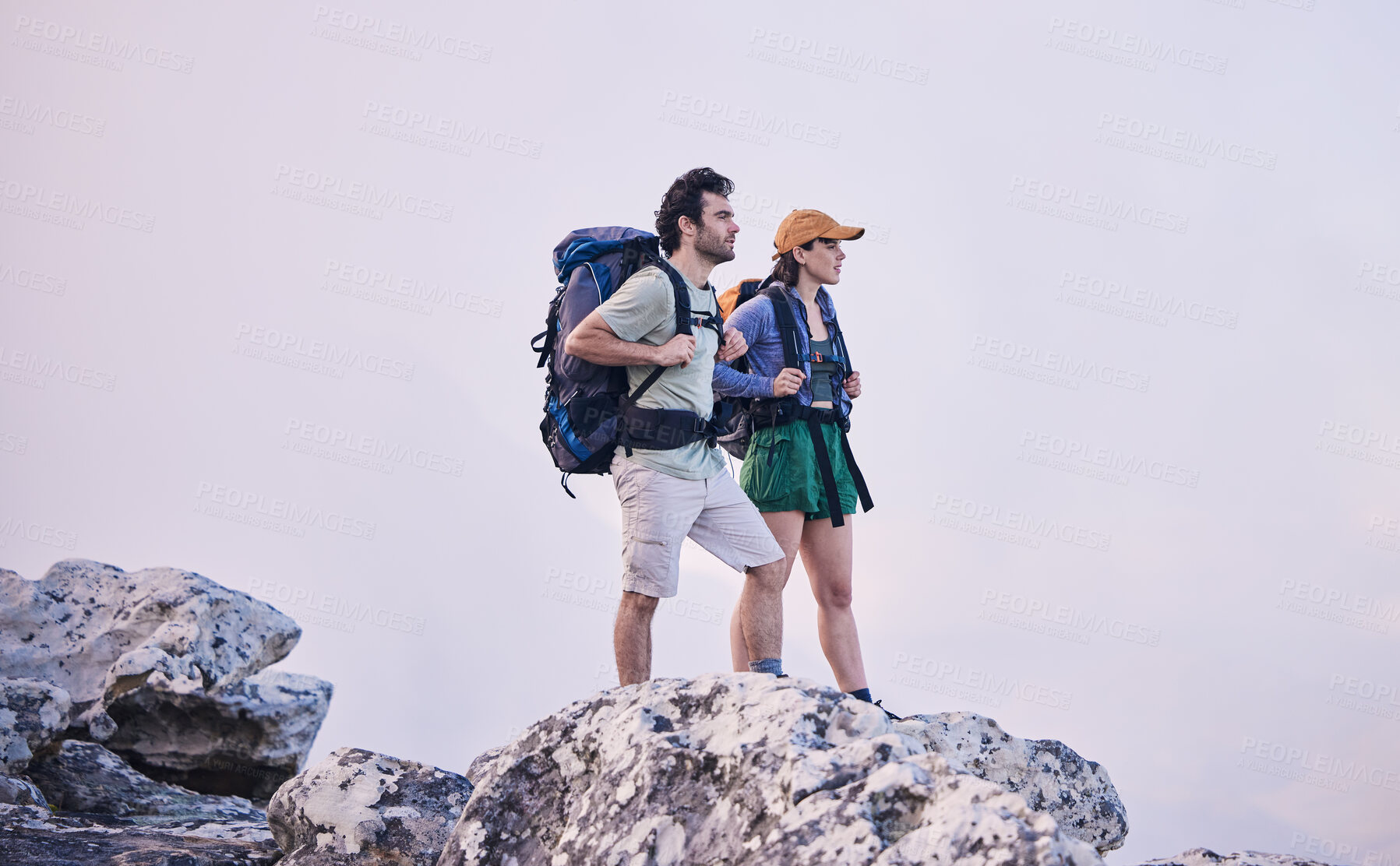 Buy stock photo Mountains, hiking and man with woman on cliff for adventure in nature, landscape and travel. Outdoor trekking, couple on peak and relax in scenic clouds for natural journey, walking and rock climbing