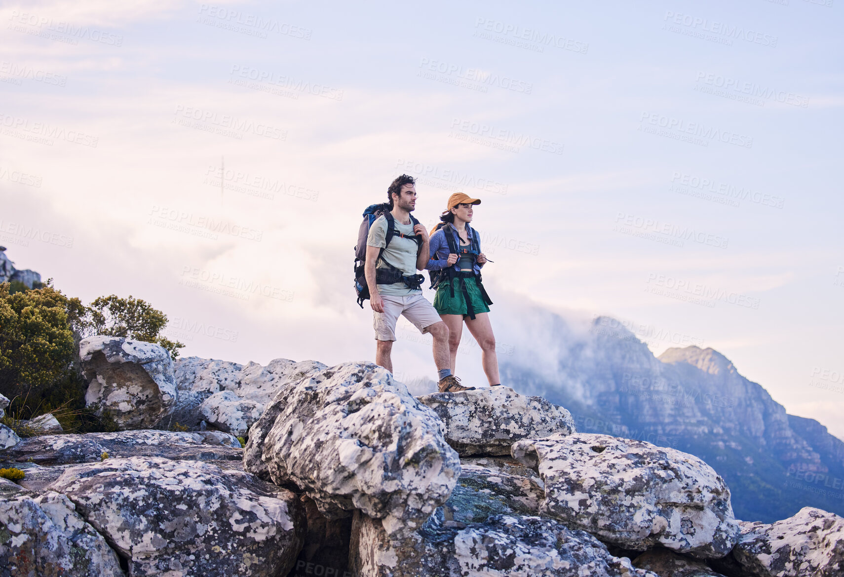 Buy stock photo Mountain, hiking view and man with woman on peak for adventure in nature, landscape and travel. Outdoor trekking, couple on cliff and relax in scenic clouds for natural journey, walking and looking.