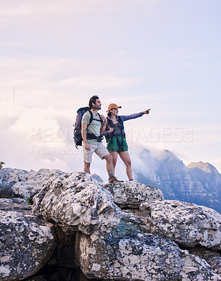 Buy stock photo Mountains, hiking and pointing, man and woman on peak for adventure in nature, landscape and travel. Outdoor trekking, couple on cliff and relax in scenic clouds for natural journey, view and looking