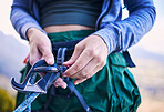 Rock climbing, mountain and hands of woman with gear for adventure, freedom and extreme sports. Fitness, nature and female person with carabiner equipment closeup for training, activity and challenge