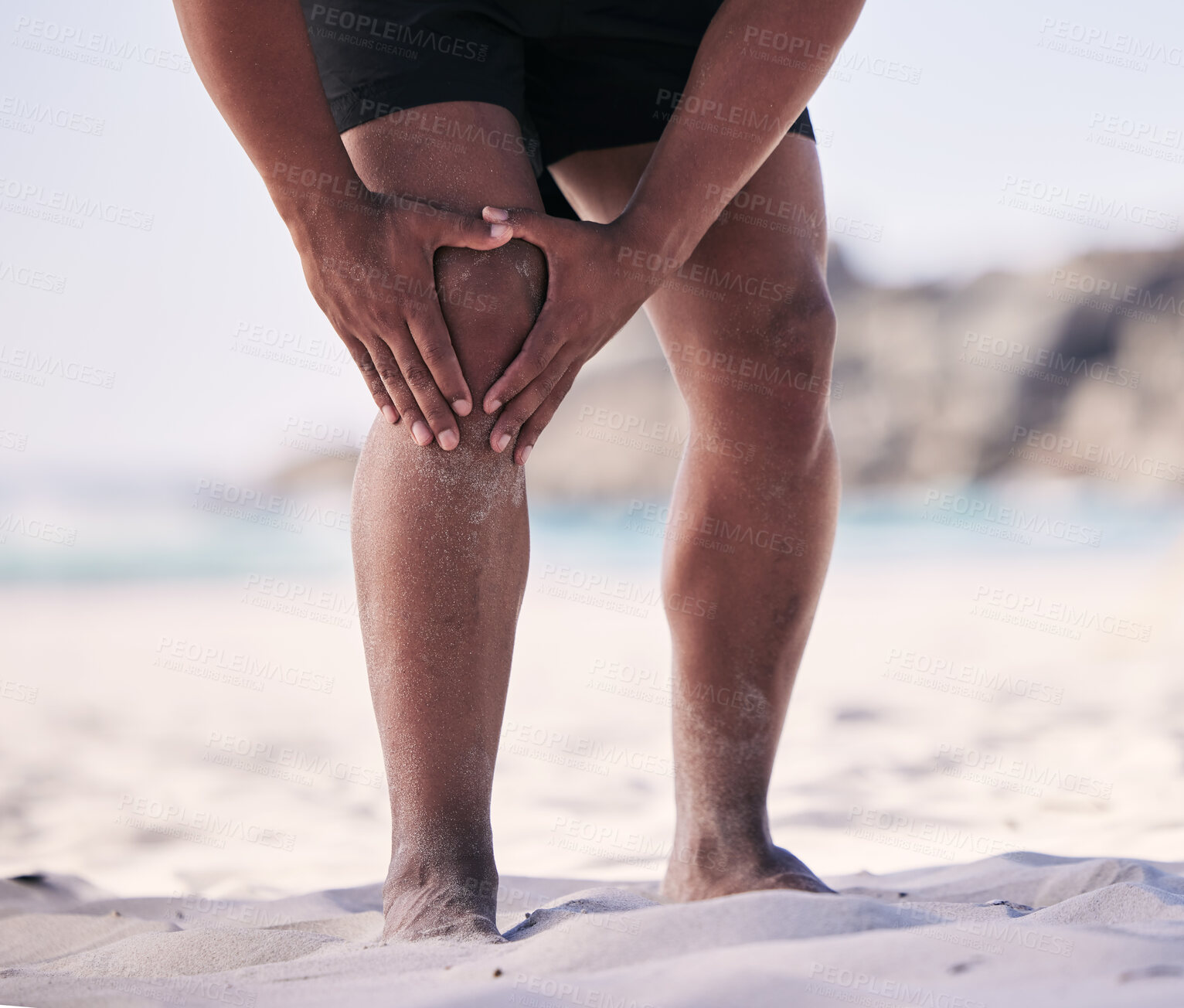 Buy stock photo Hands, knee pain and man at a beach for fitness, exercise and performance training with problem. Leg, injury and male player with arthritis, fibromyalgia or osteoporosis crisis during workout 