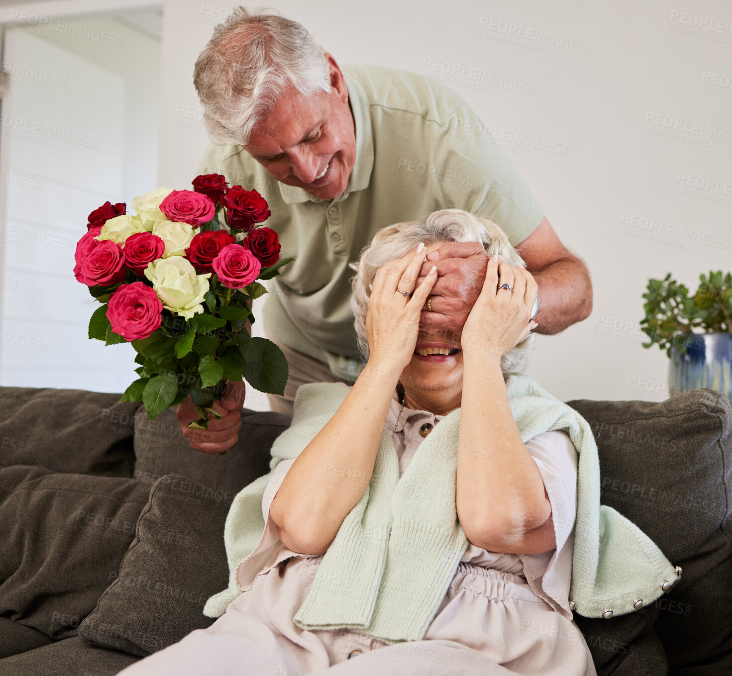 Buy stock photo Senior couple, surprise and flowers gift for love and valentines day in a home. Living room couch, closed eyes and smile with elderly woman and man together in retirement with bouquet in a house