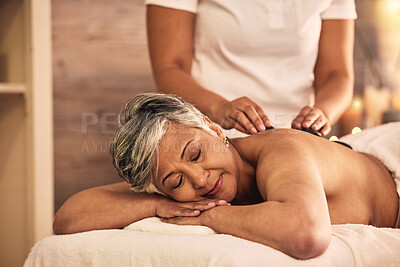 Buy stock photo Woman, spa and stone massage for healing back muscle, skincare treatment and holistic therapy at beauty salon. Mature female person relax at wellness resort with rocks for self care, detox and zen