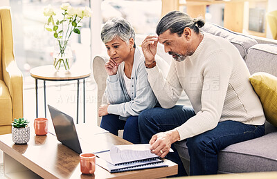 Buy stock photo Senior couple, laptop and financial crisis on sofa with documents in budget struggle or debt at home. Frustrated elderly man and woman with computer for finance, bills or expenses in the living room