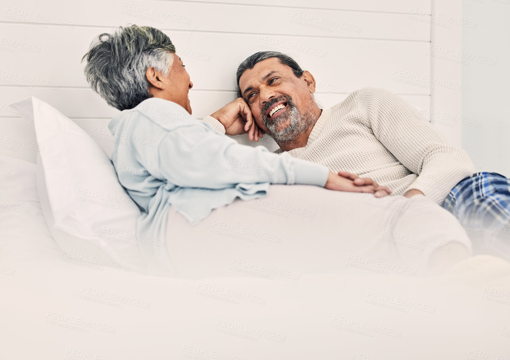 Buy stock photo Love, relax and a senior couple in bed together, bonding in the morning while enjoying retirement in their home. Happy, conversation and an old man with his wife in the bedroom while on holiday