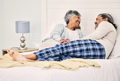 Buy stock photo Love, relax and an elderly couple in bed together, bonding in the morning while enjoying retirement in their home. Happy, conversation and an old woman with her husband in a bedroom while on holiday