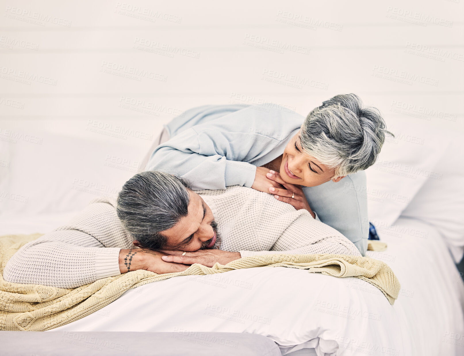 Buy stock photo Happy senior couple, bed and laying in home, hotel and together for romance, chat or conversation in morning. Elderly woman, old man and talk on vacation, holiday or relax in bedroom, bonding or love