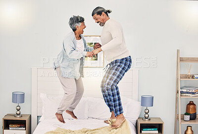 Buy stock photo Happy, playful or old couple jumping on bed to relax, enjoy holiday or fun morning together at home. Playing, silly senior woman or elderly man laughing or bonding with love or smile in retirement 